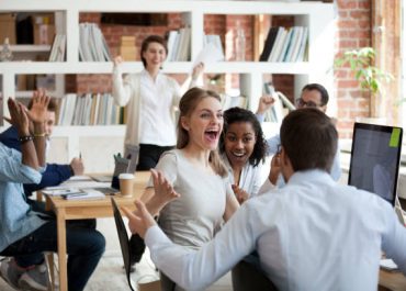 Excited diverse business team employees screaming celebrating good news business win corporate success, happy multi-ethnic colleagues workers group feeling motivated ecstatic about great achievement